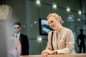 polite businesswoman talking to receptionist in hotel, hospitality industry