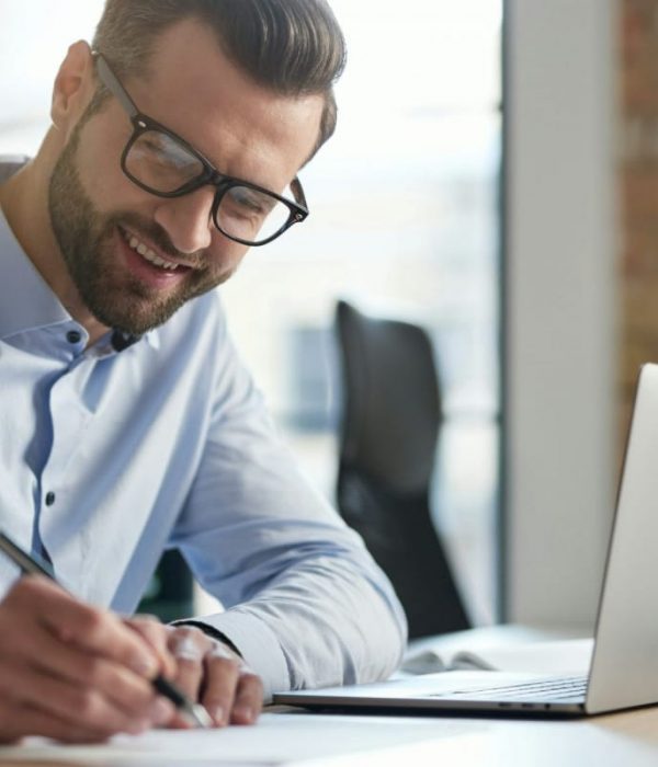 Contented young manager signing the documents and smiling